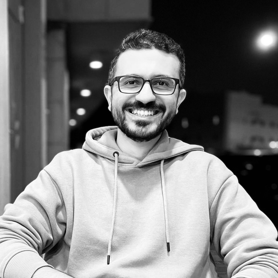 Osama Adel — black-and-white portrait, smiling at camera